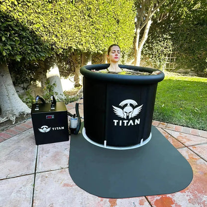 Woman immersed in Titan Bravo cold plunge with Titan chiller on backyard patio mat, outdoor ice bath setup in a garden