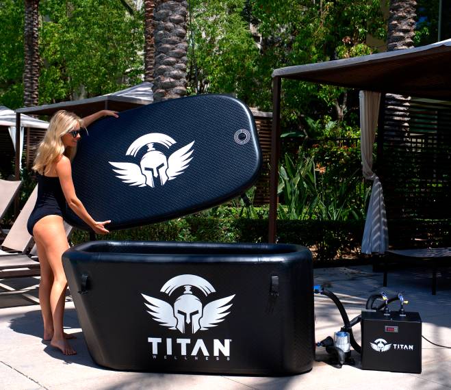 Woman lifting Titan Triumph cold plunge cover, triumph ice bath with Titan chiller on poolside patio, durable drop stitch PVC